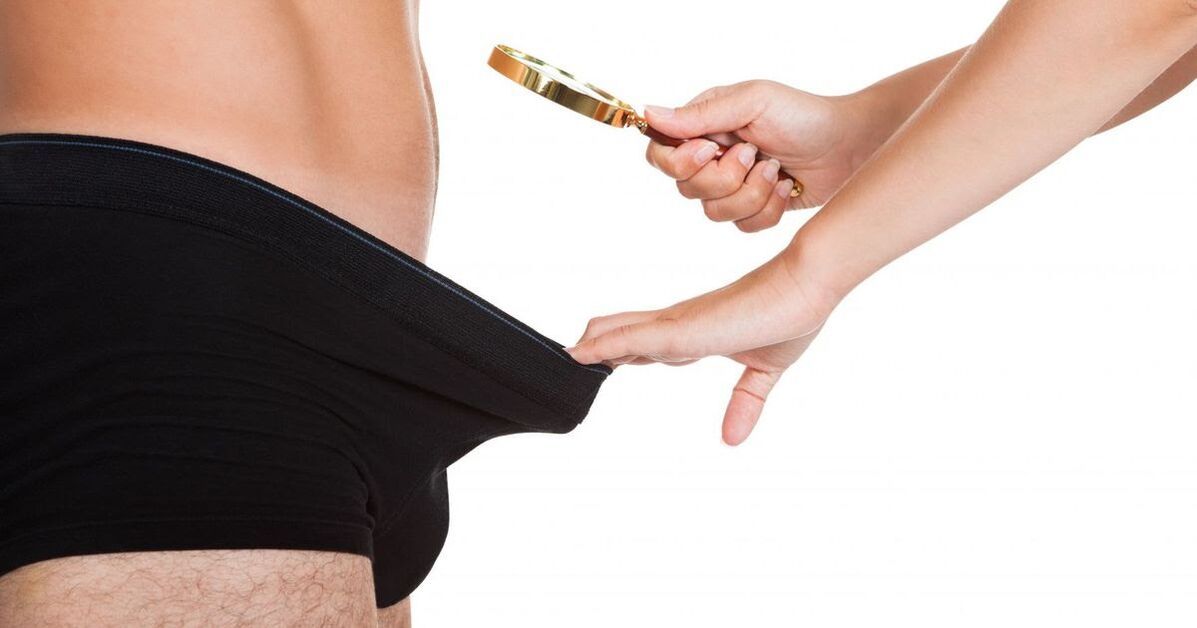 Ein Mädchen blickt durch eine Lupe auf einen kleinen Penis.